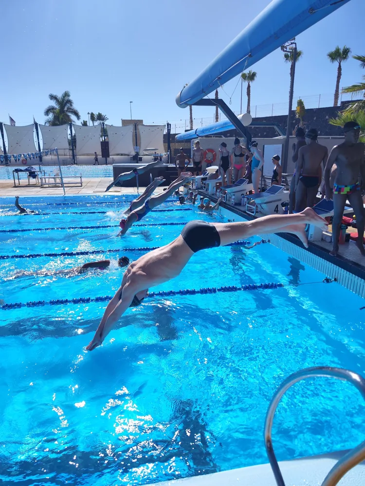 A swimmer flying off the block mid-dive
