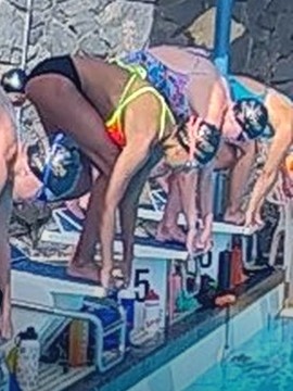 Camp photo of a swimmer taking their mark on the start block