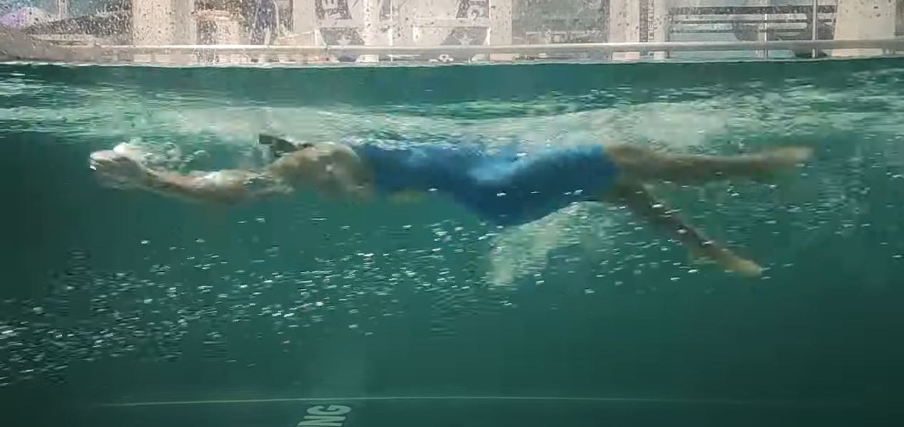 Underwater view of a swimmer being filmed mid-stroke in the Swimpros flume channel
