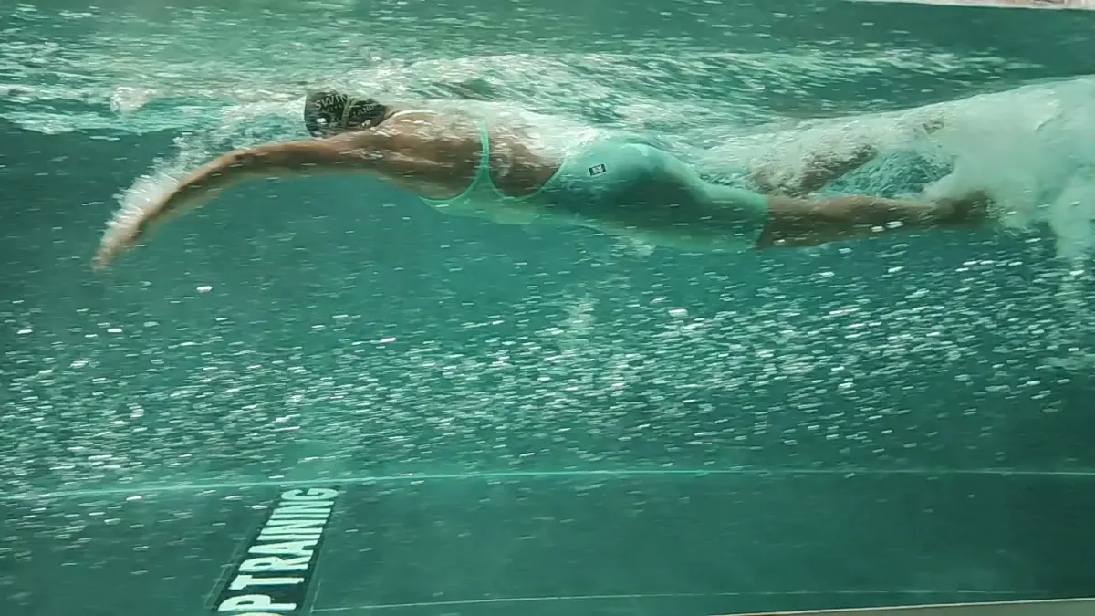 A swimmer filmed side-on under water in the flume