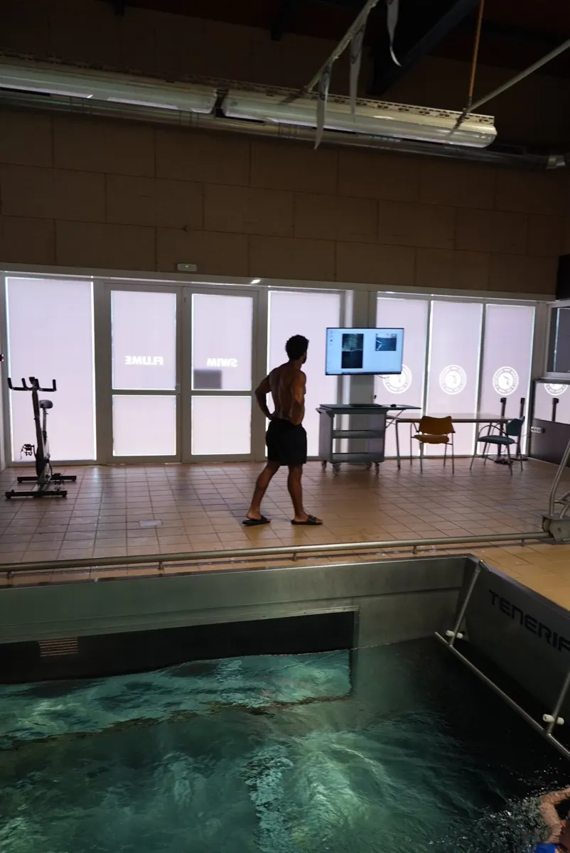 Coach at the video-analysis screen beside the flume