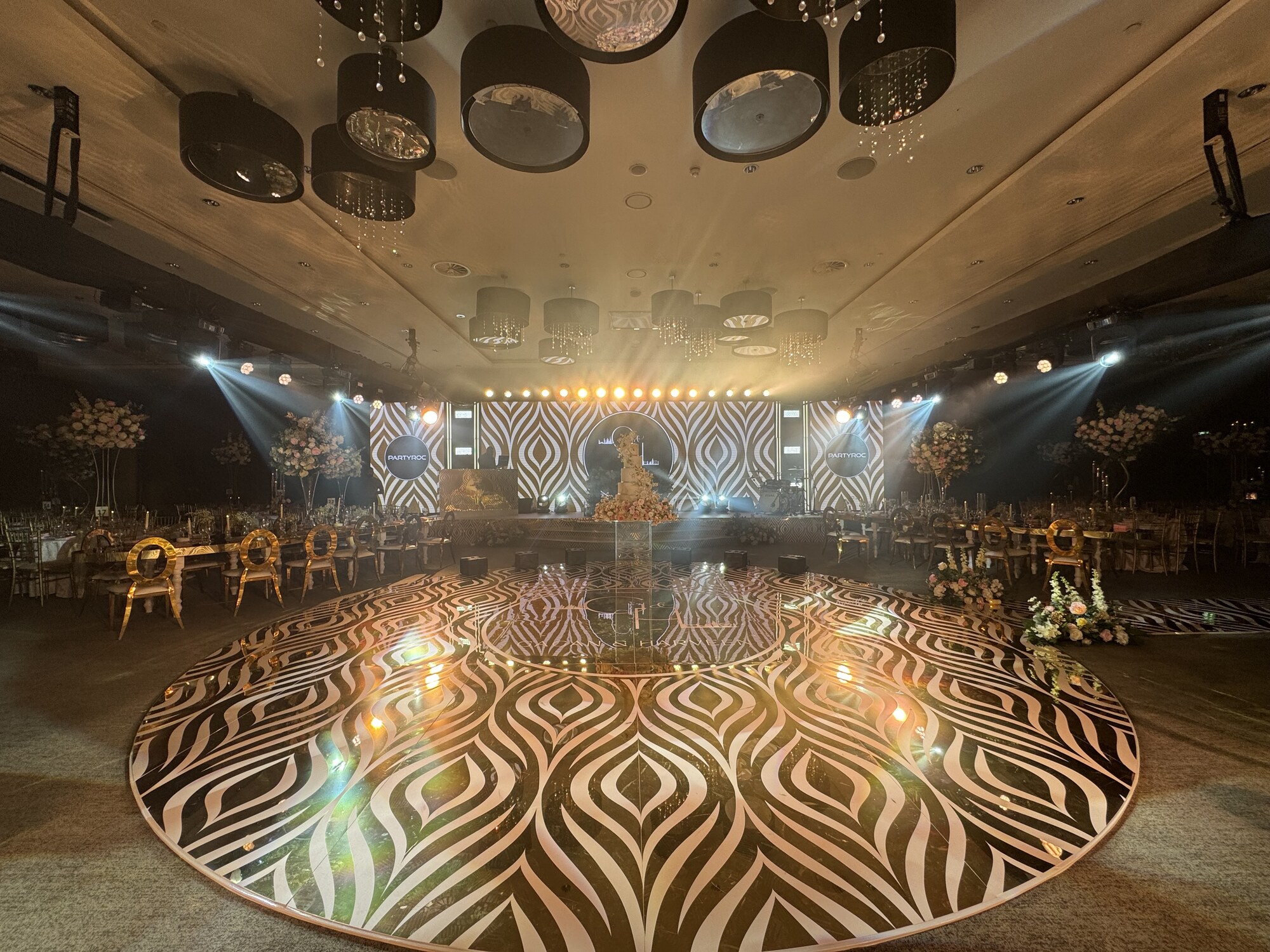 Gold ballroom setup with patterned LED wall and bespoke round dance floor