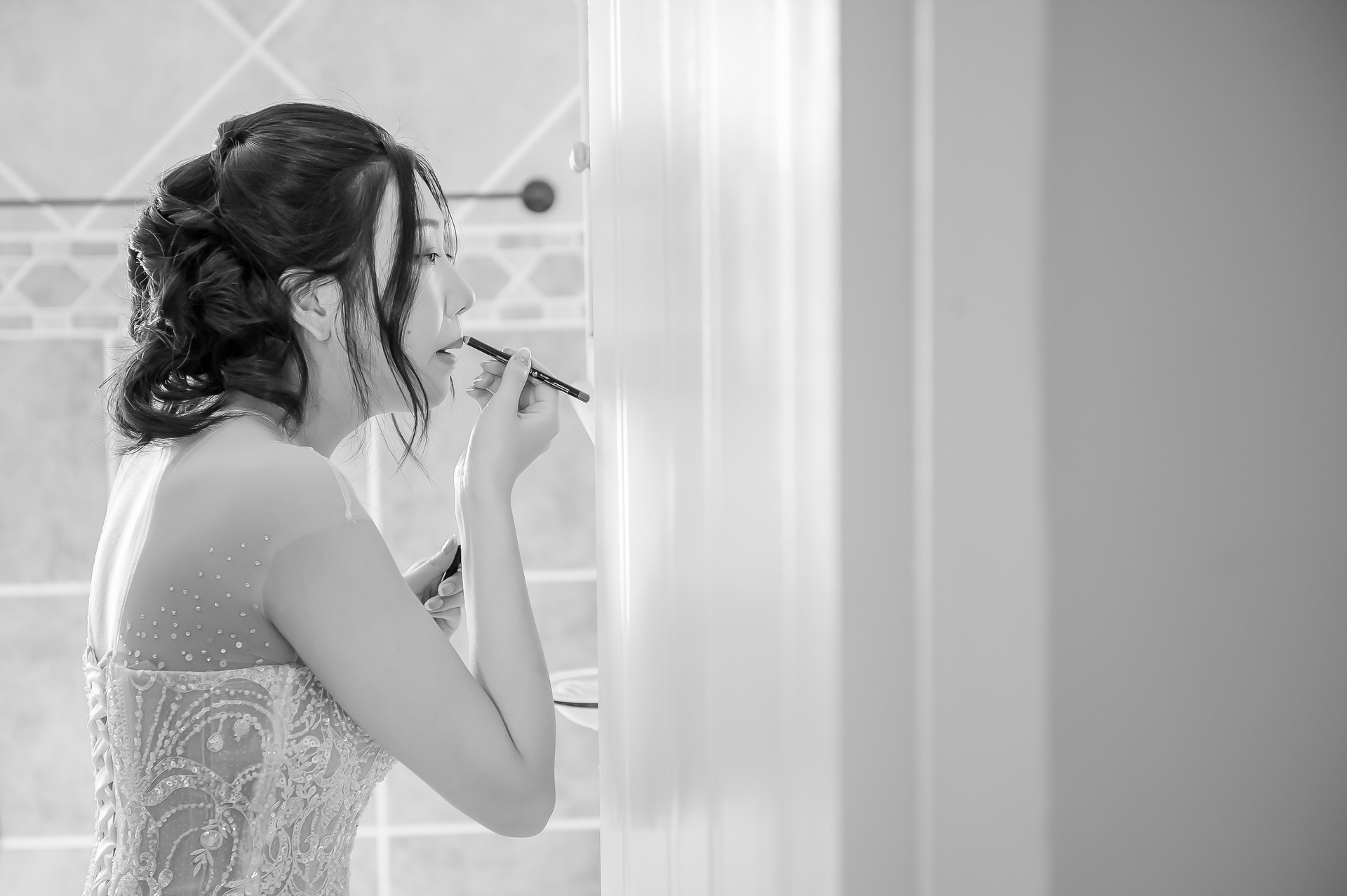 A bride doing her make-up at a mirror