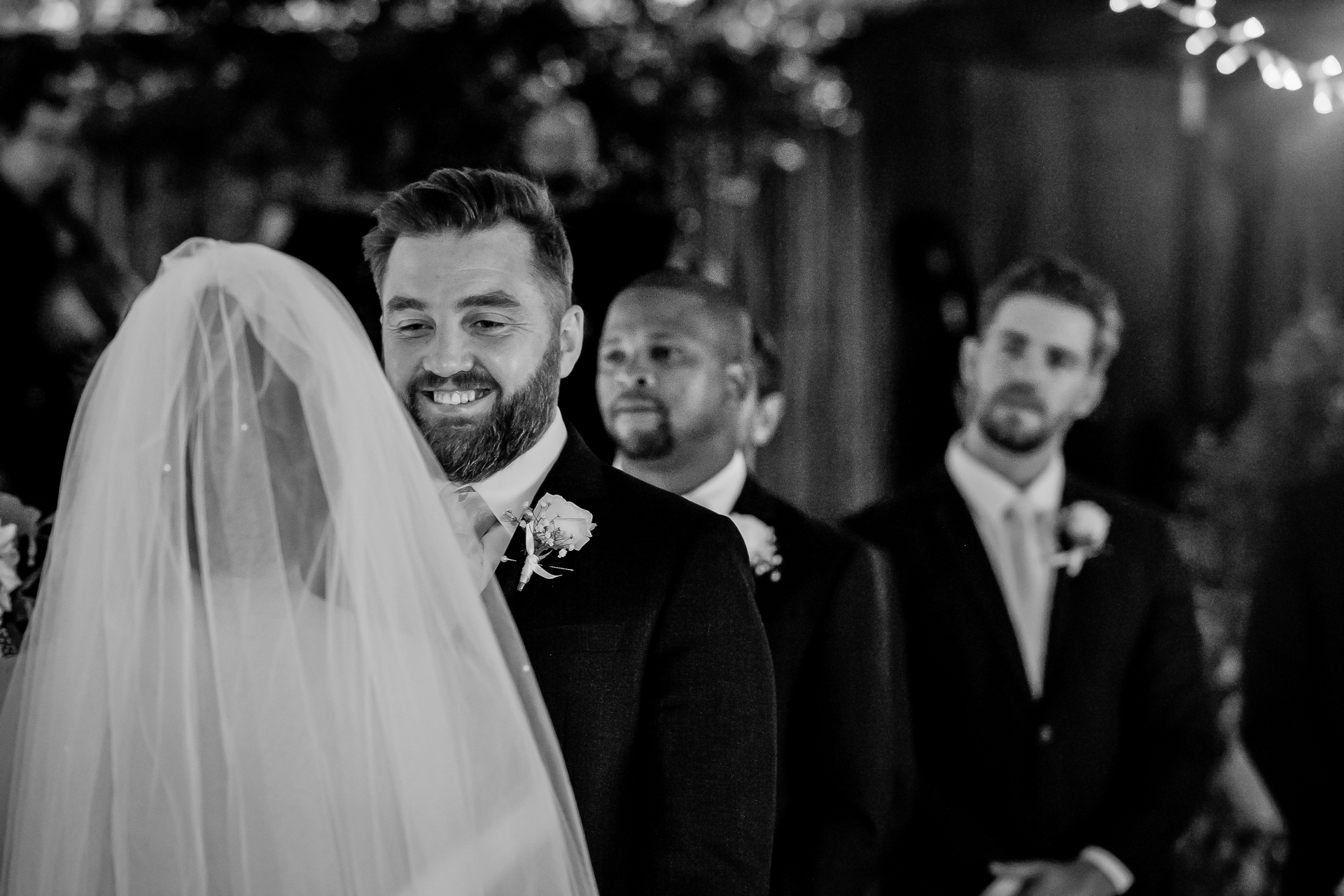 A groom smiling at his bride during the ceremony