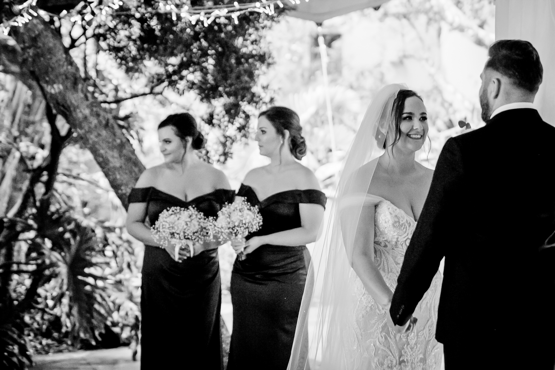 A bride and her bridesmaids walking up to the groom