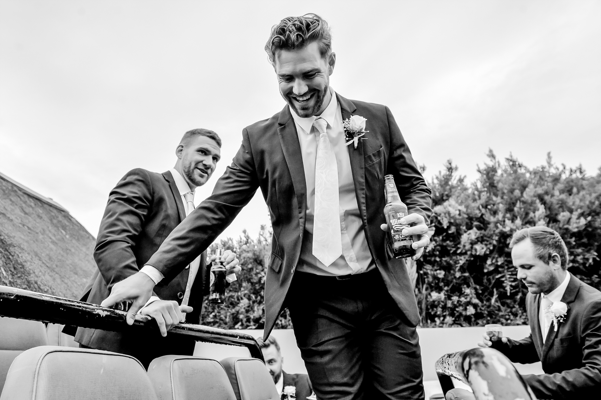 A groom laughing as he climbs off a game drive vehicle