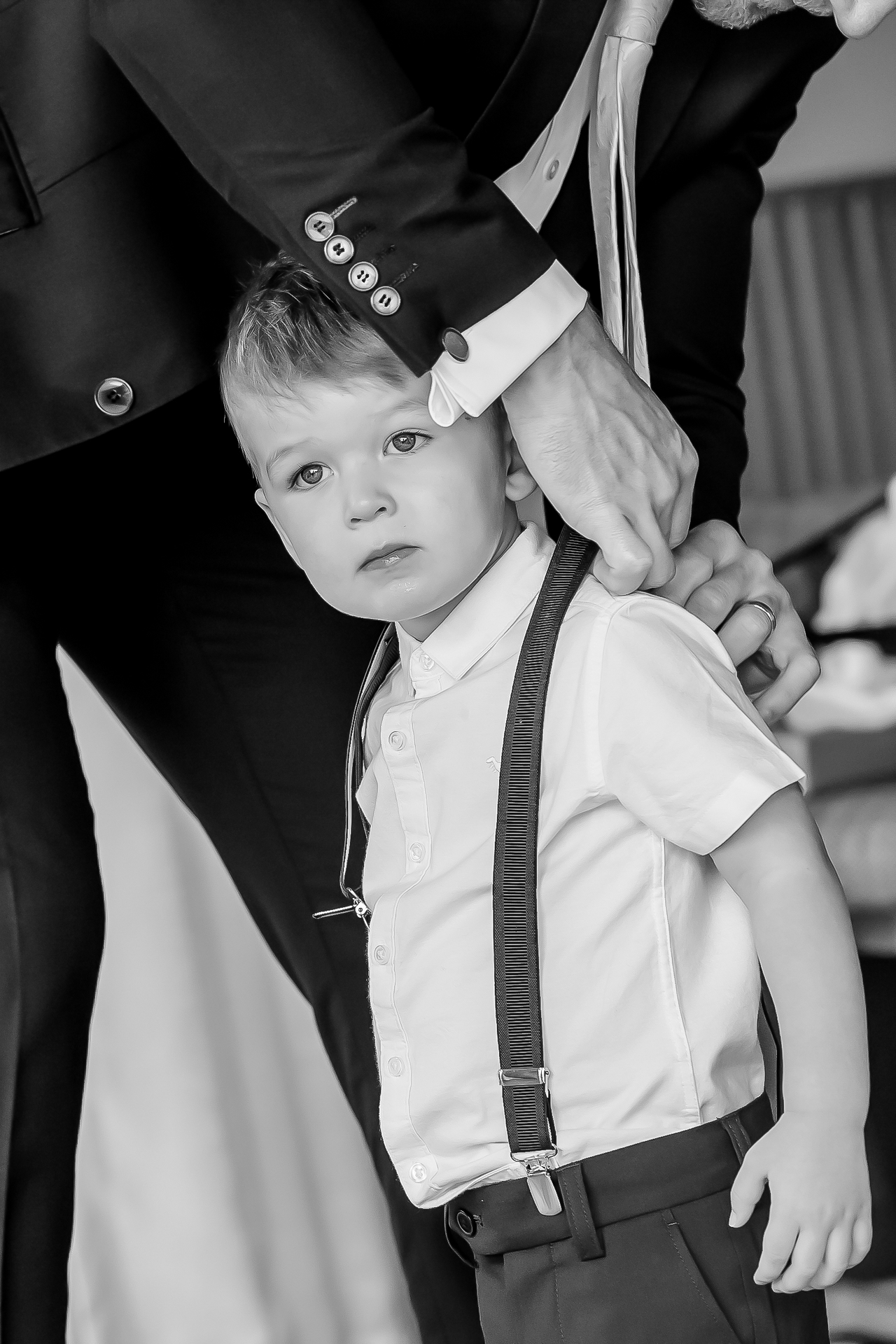 A little page boy in braces, a man in a suit resting a hand on his shoulder