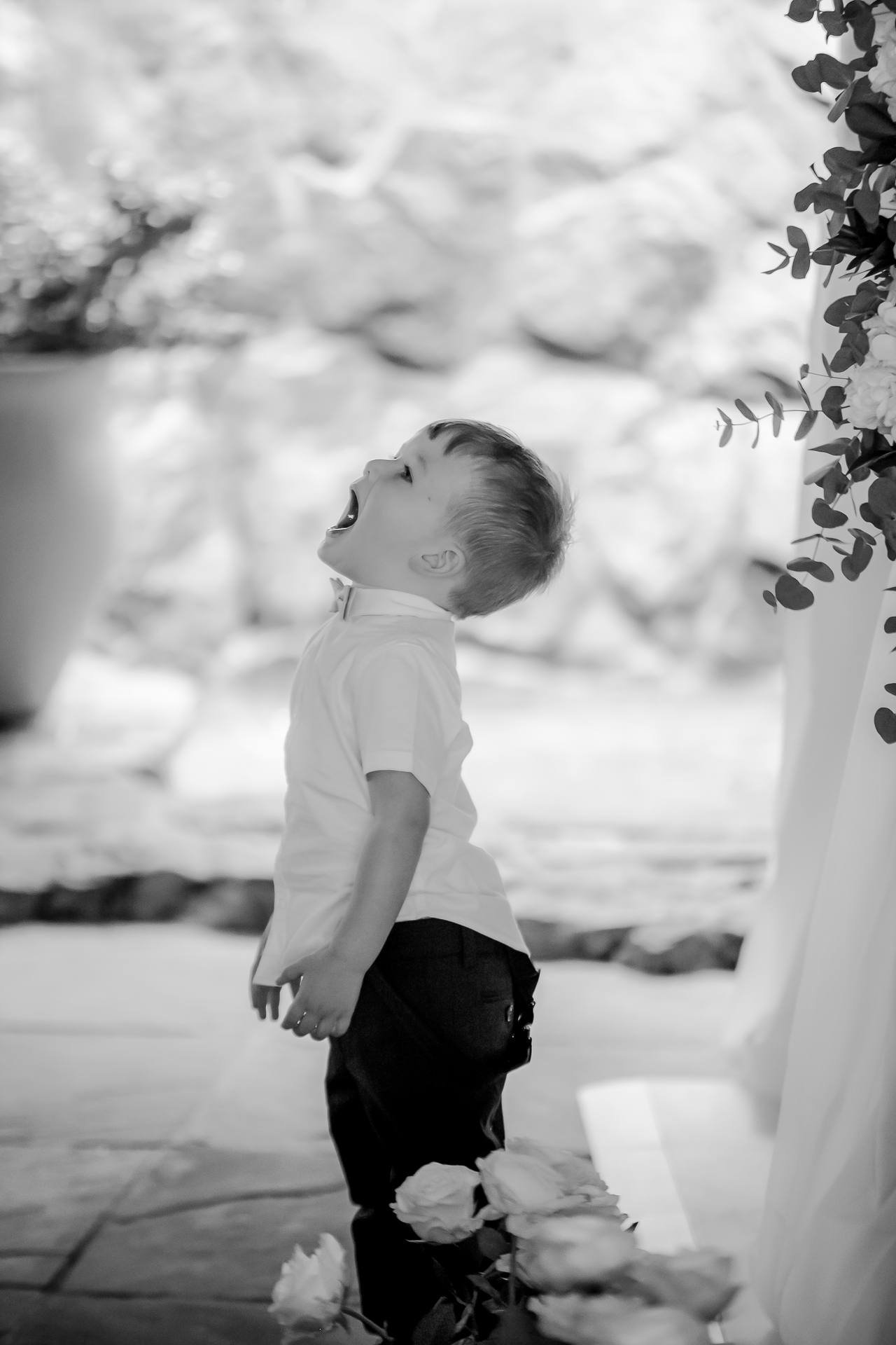 A page boy in a waistcoat looking up during a wedding