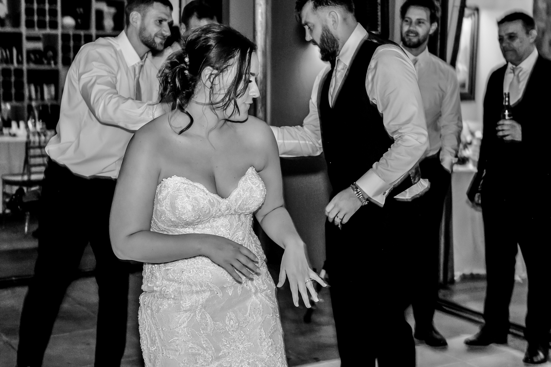 A bride laughing with the groomsmen at the reception