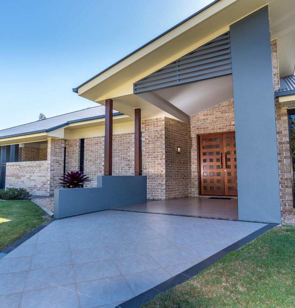 Modern full home remodel in Carrollton TX featuring updated exterior design, brick accents, and custom front entry