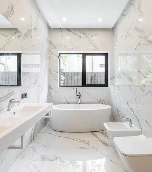 Luxury bathroom remodeling in Carrollton, TX with marble walls, soaking tub, and modern fixtures