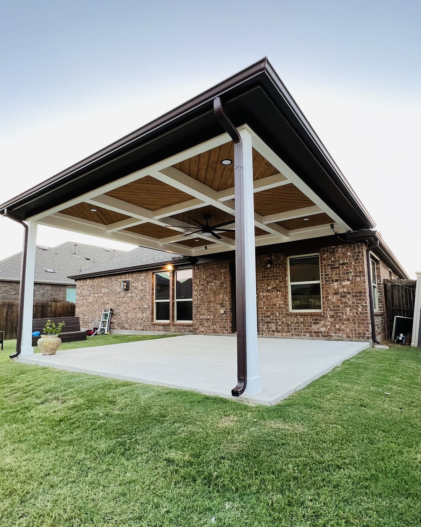 Modern flat roof custom patio cover in Carrollton, TX with ceiling fans and durable post construction.