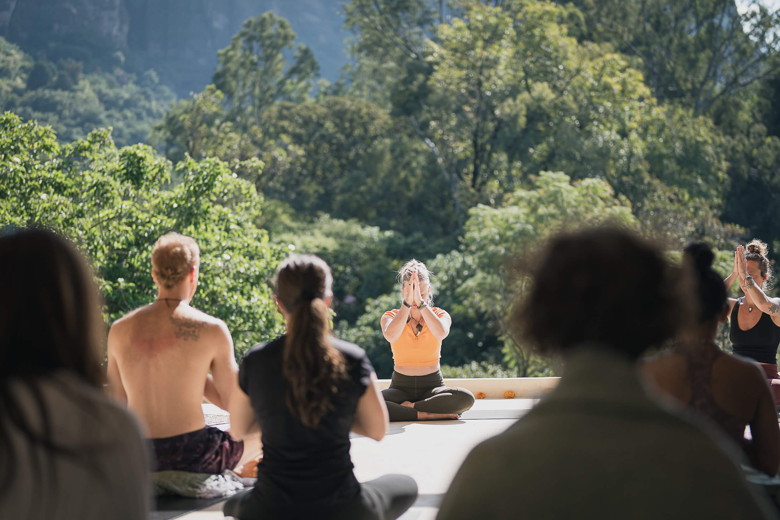 Yoga practitioners in serene Anjali Mudra pose amidst lush Mexican scenery, capturing the essence of tranquility in lifestyle photography by Matt Anthony Photography.