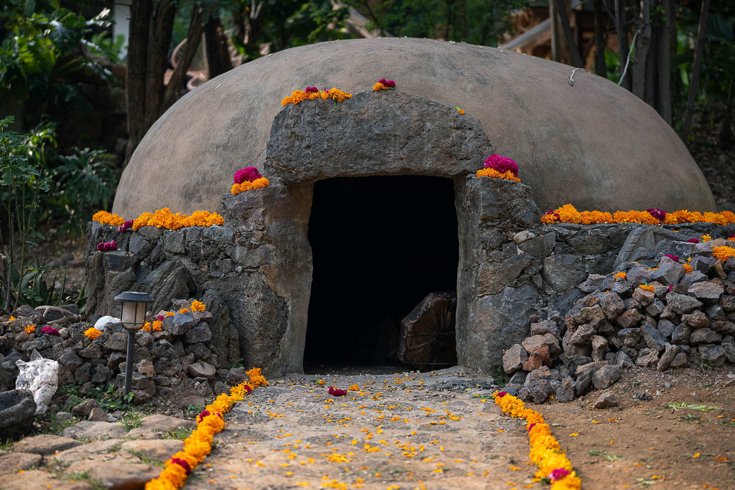 Close-up of the temazcal and ceremonial setup with vibrant marigold arrangements