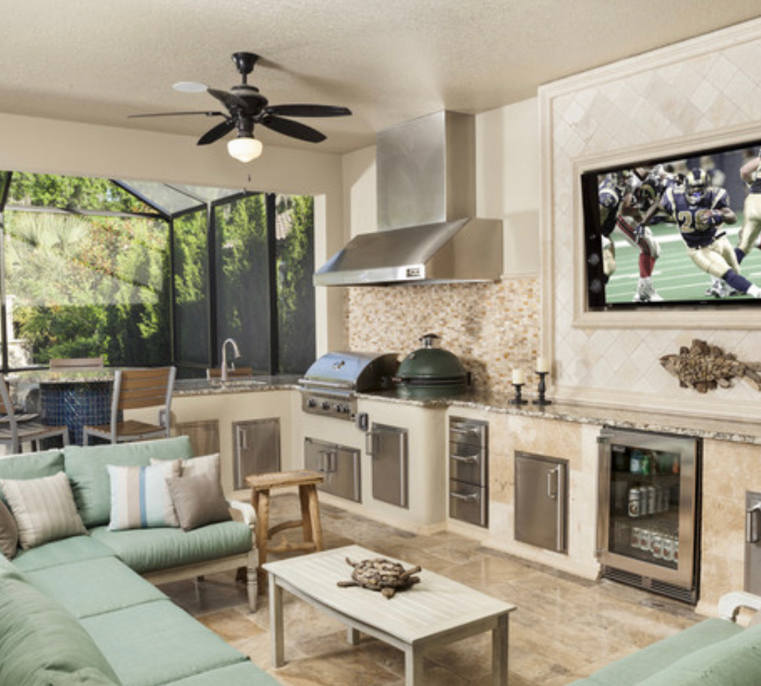 Outdoor living space with fireplace, outdoor kitchen, travertine patio and artificial turf — Aeroscapes Landscaping Frisco TX