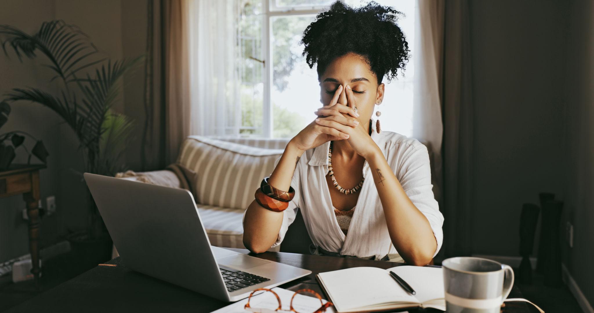 woman sitting in front of a computer overwhelmed and experiencing anxiety