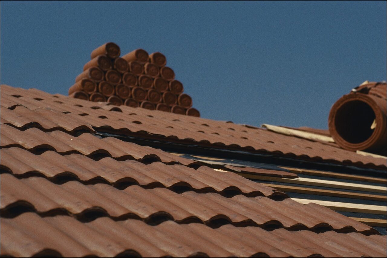 Clay barrel roof tiles during installation