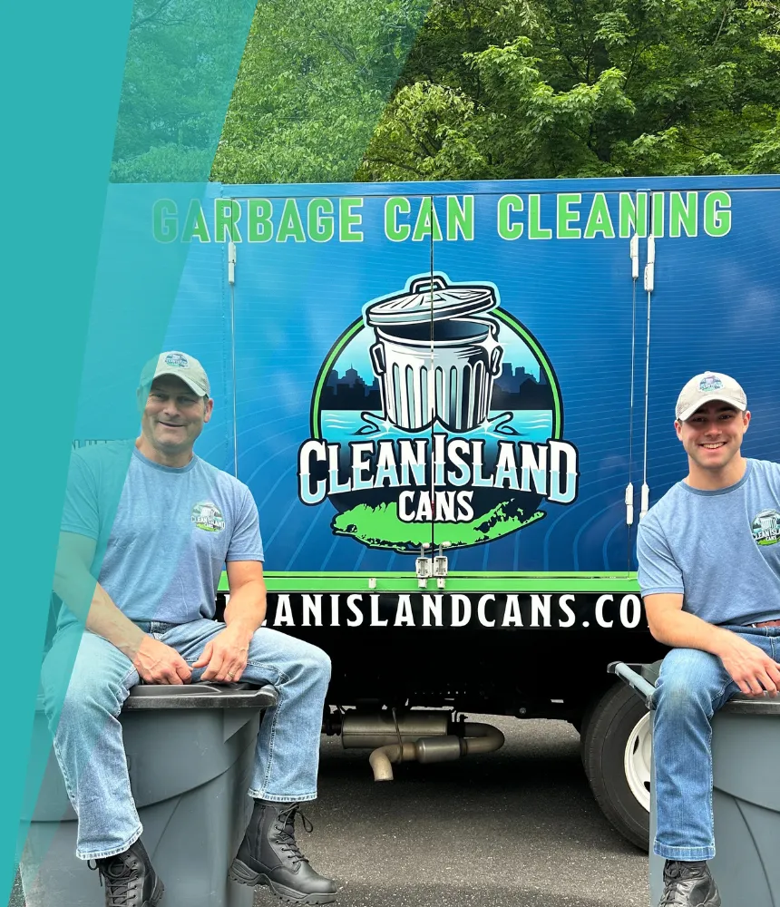 Two Clean Island Cans team members sitting on garbage bins in front of their branded cleaning truck, smiling proudly. 