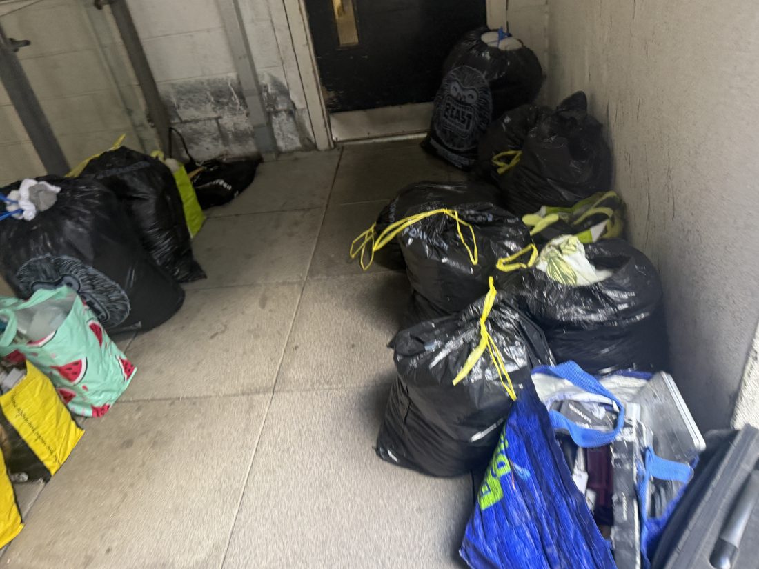 Packed bags and household belongings beside the access route on a Liverpool moving job
