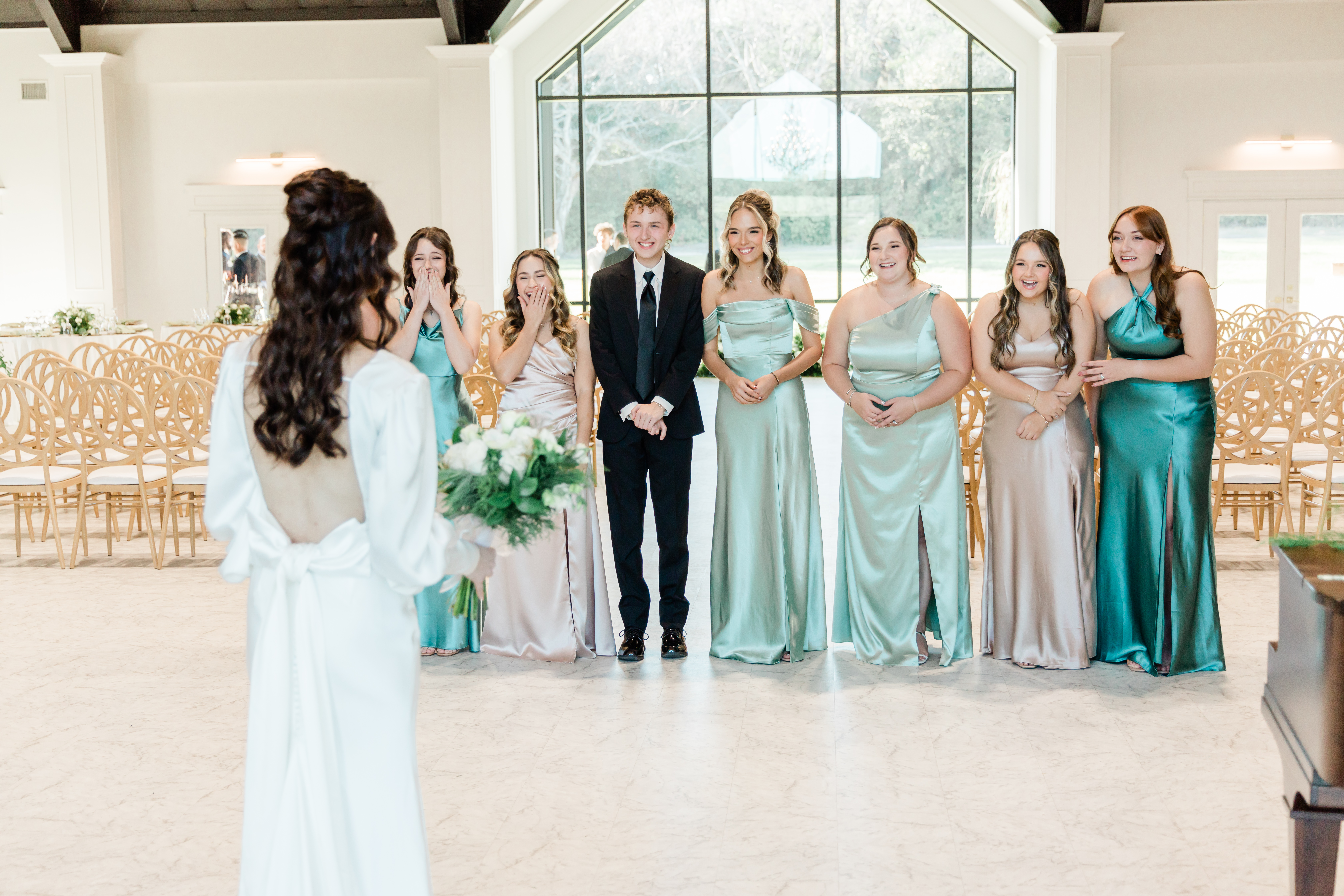 Image of a bride standing in front of her bridal attendants for a first reveal. Captured by Dallas wedding photographer Arlene Stepanian.