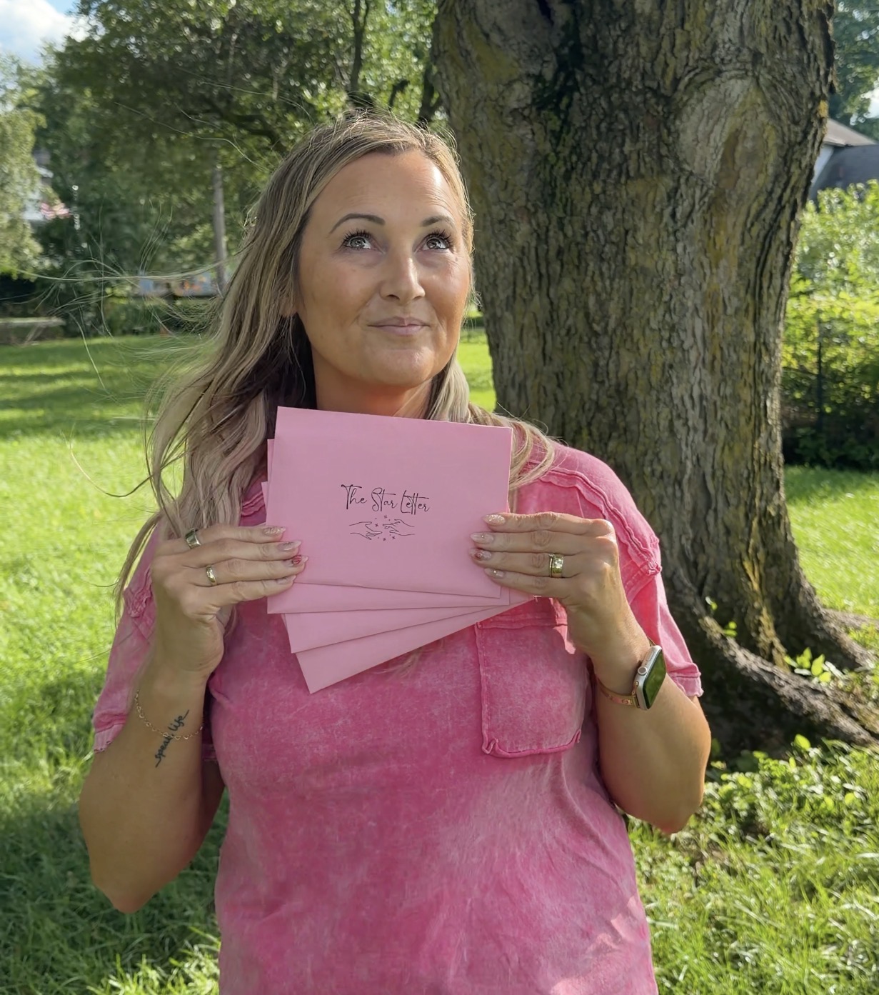 Sarah L. Fields Holding Star Club Pink Envelopes