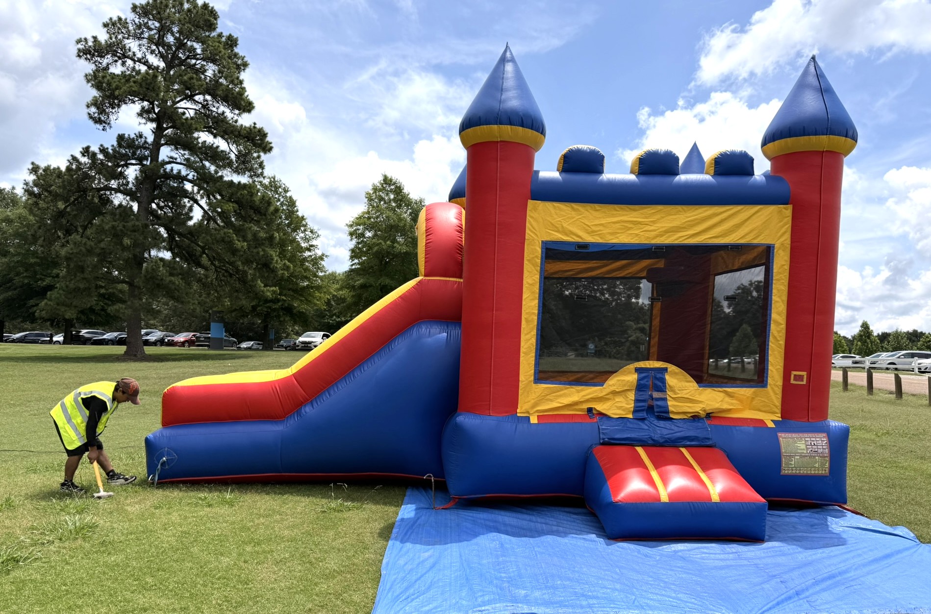 Tiky Jumps technician setting up a bounce house safely in a Germantown backyard