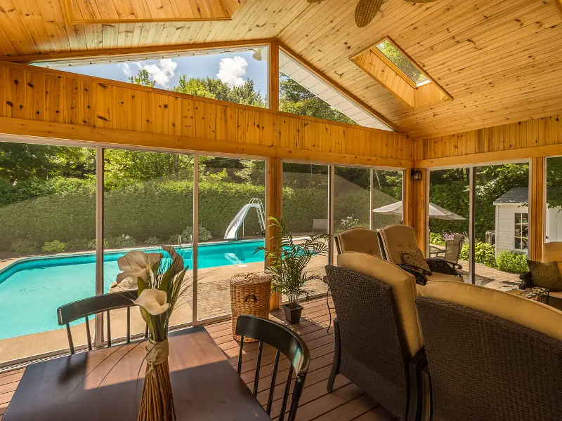 Screened porch with skylight and dining table overlooking pool. Screened porch with skylight and dining table overlooking pool.
