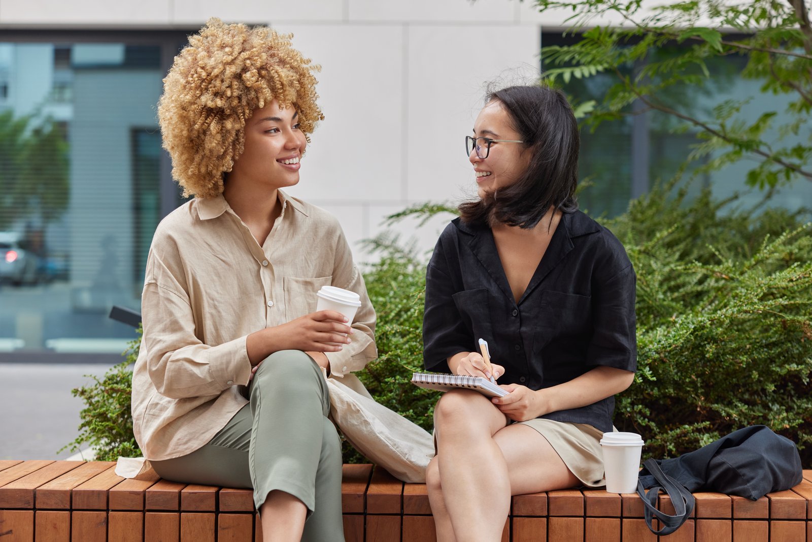 Two people talking outside over coffee