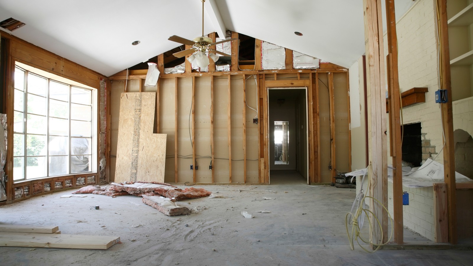 A gutted interior mid-renovation with exposed framing and materials on the floor
