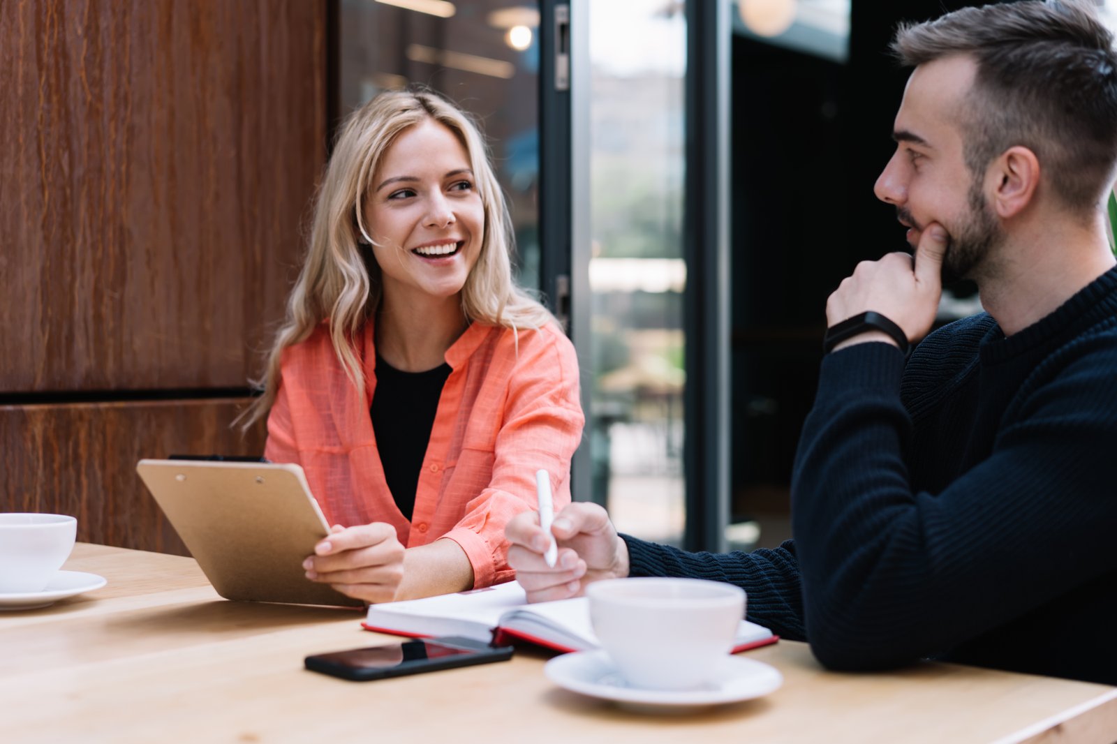 Two people comparing notes over coffee