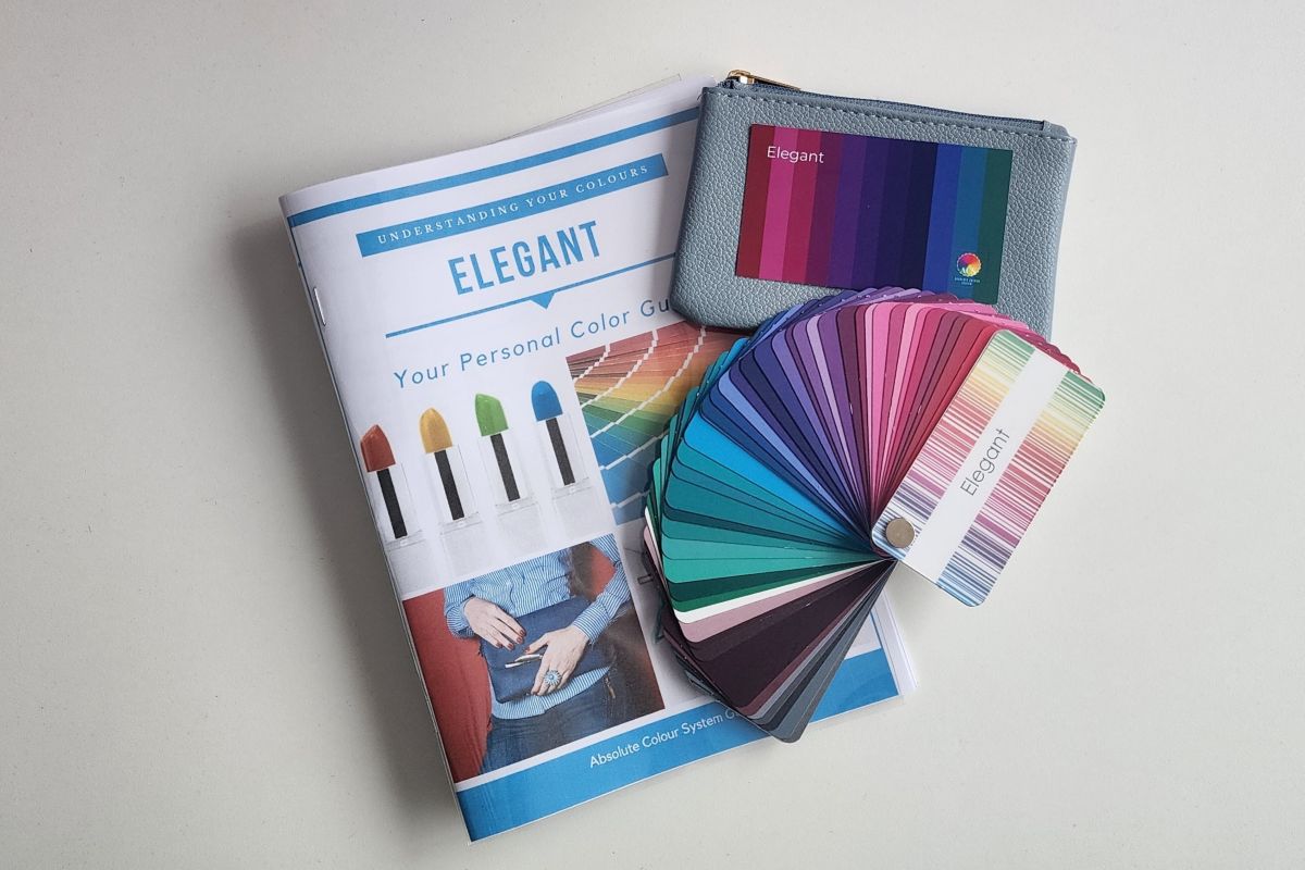 A colour swatch, a printed guide and a marked up style page laid out on a cream cloth