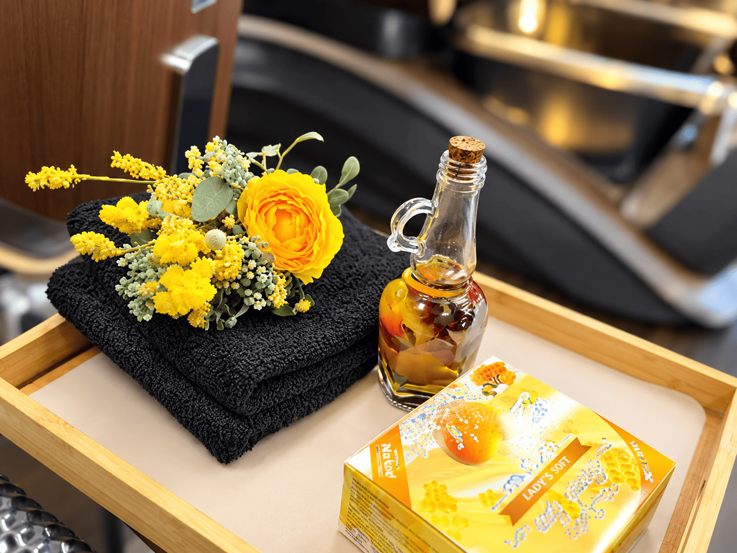 Pedicure spa add-on tray with fresh flowers, a rolled towel and scented oil