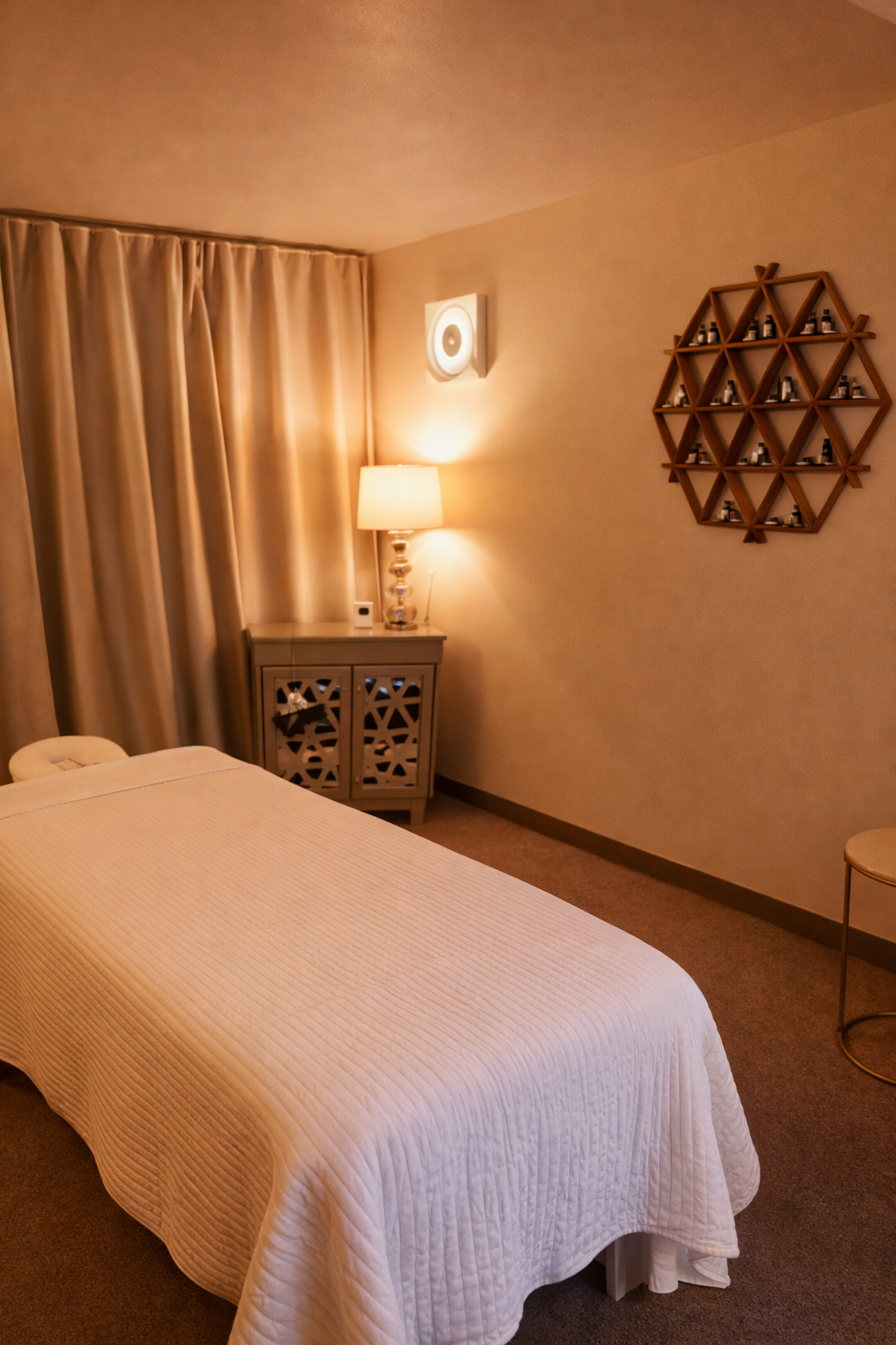 SOMA Flow massage room — warm lighting, treatment table, essential oils display