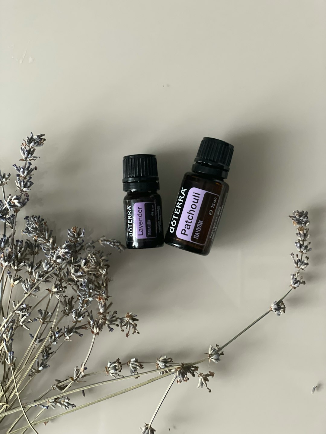 Essential oil bottles with plants — warm, natural, diverse hands