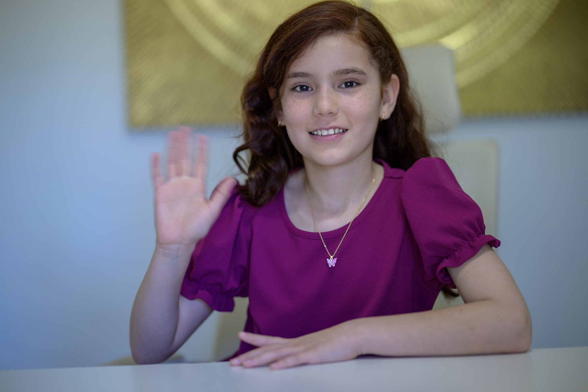 Sabrina smiling and waving hello