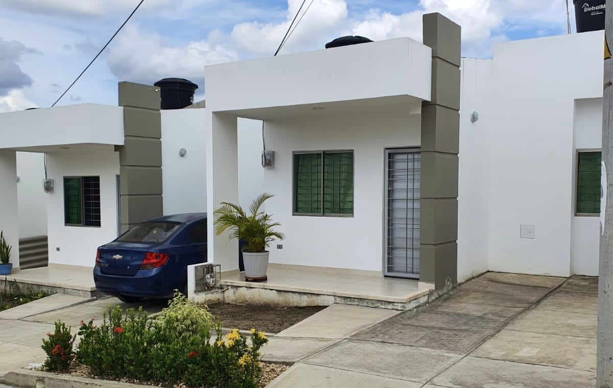 Casa de un piso ya habitada, con pilastras grises y jardín