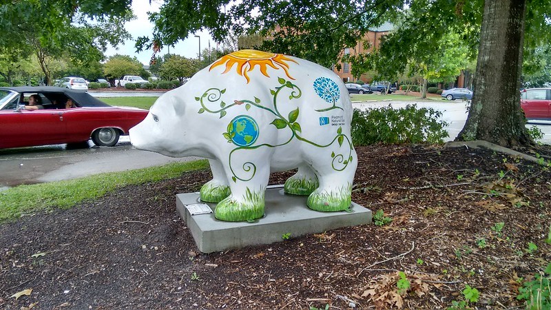 Greenzly, a white painted bear statue with a sun, vines and a globe, at Union Point Park.