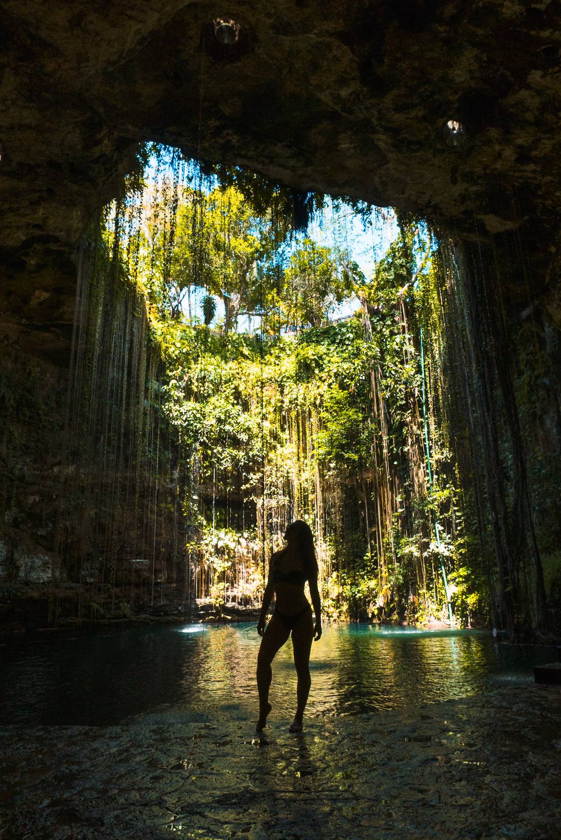 Silhouette of a person inside a jungle cenote