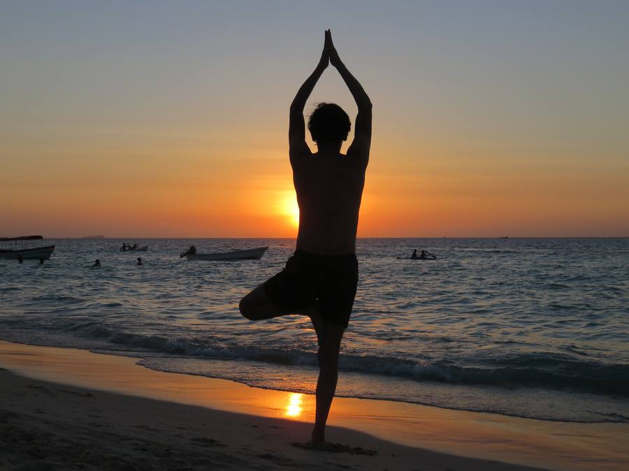 Yoga pose at sunset by the sea