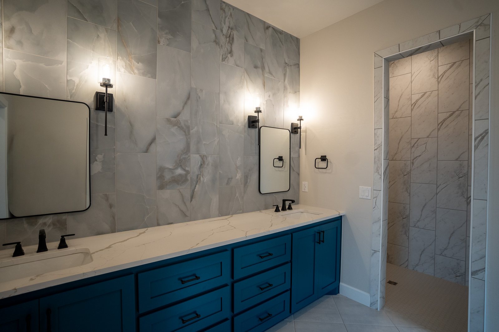 Double vanity with marble tile and black fixtures