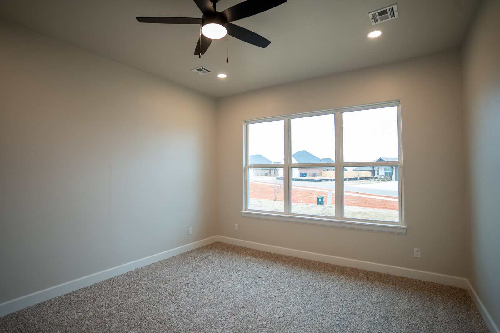 Bedroom with a vaulted ceiling and large windows