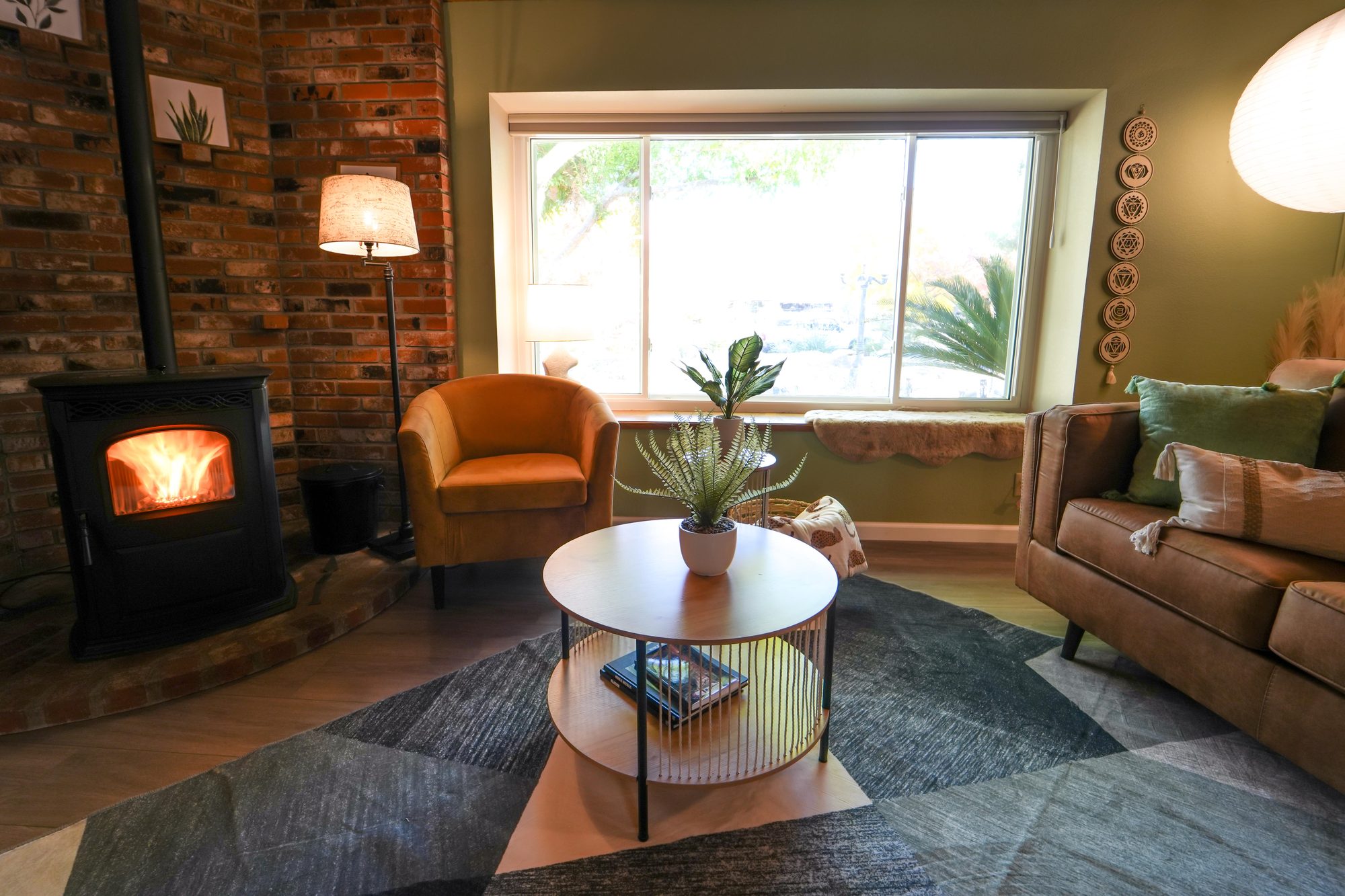 Living room with brick wall and pellet stove, a lifestyle photo representing buying a home in Tulare County