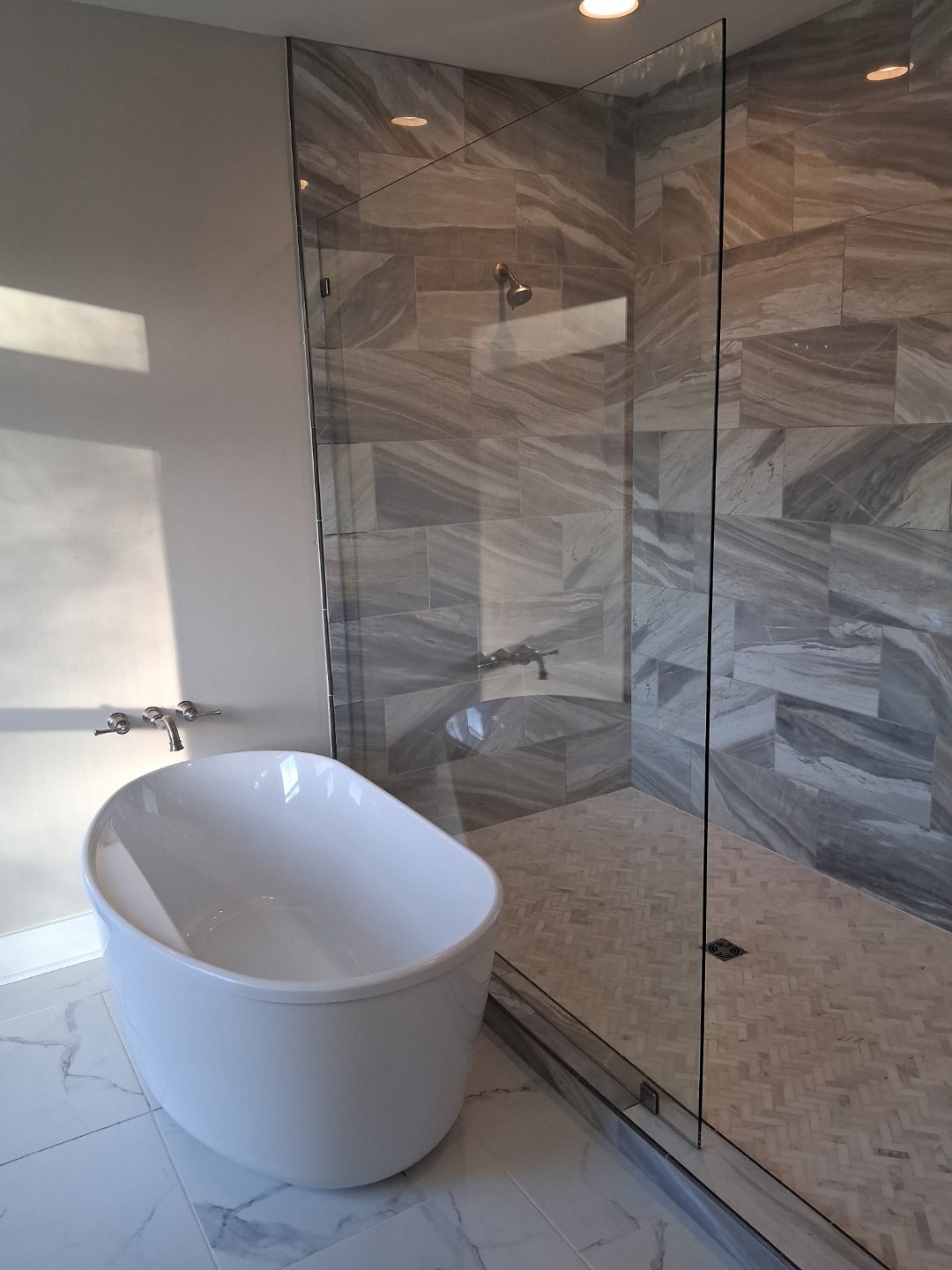 Frameless glass shower enclosure with polished chrome fixtures