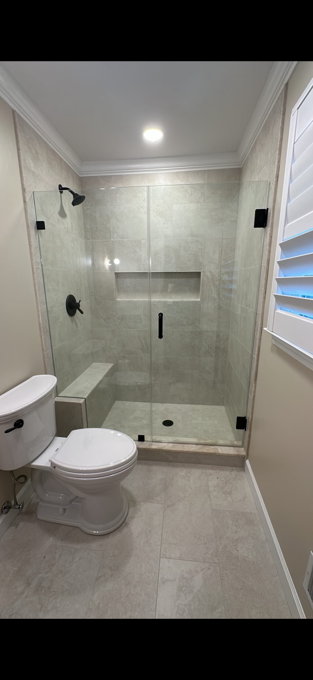 Custom shower enclosure with built-in bench and clear glass
