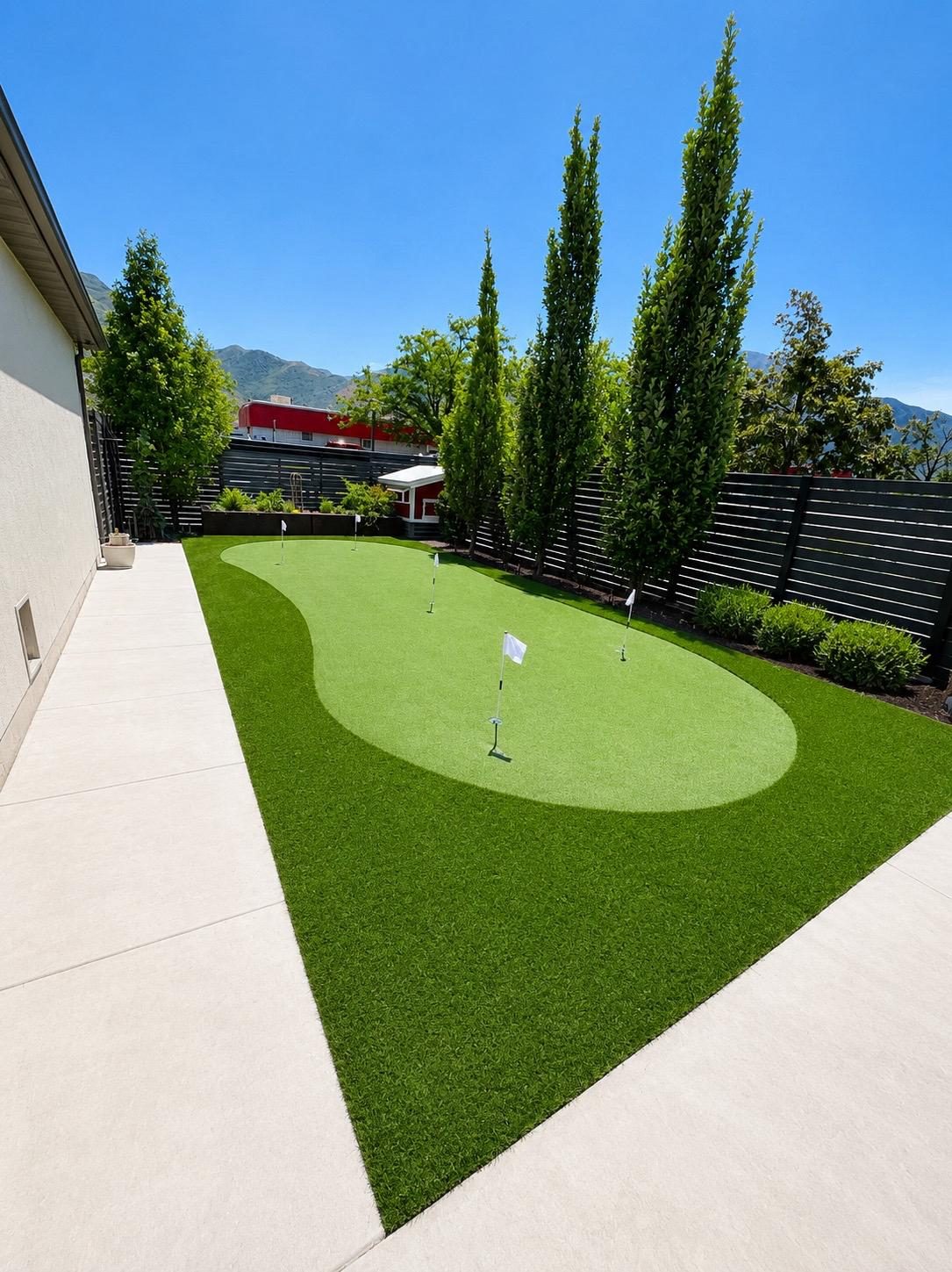 Artificial turf installation in Utah. Putting green framed by arborvitae
