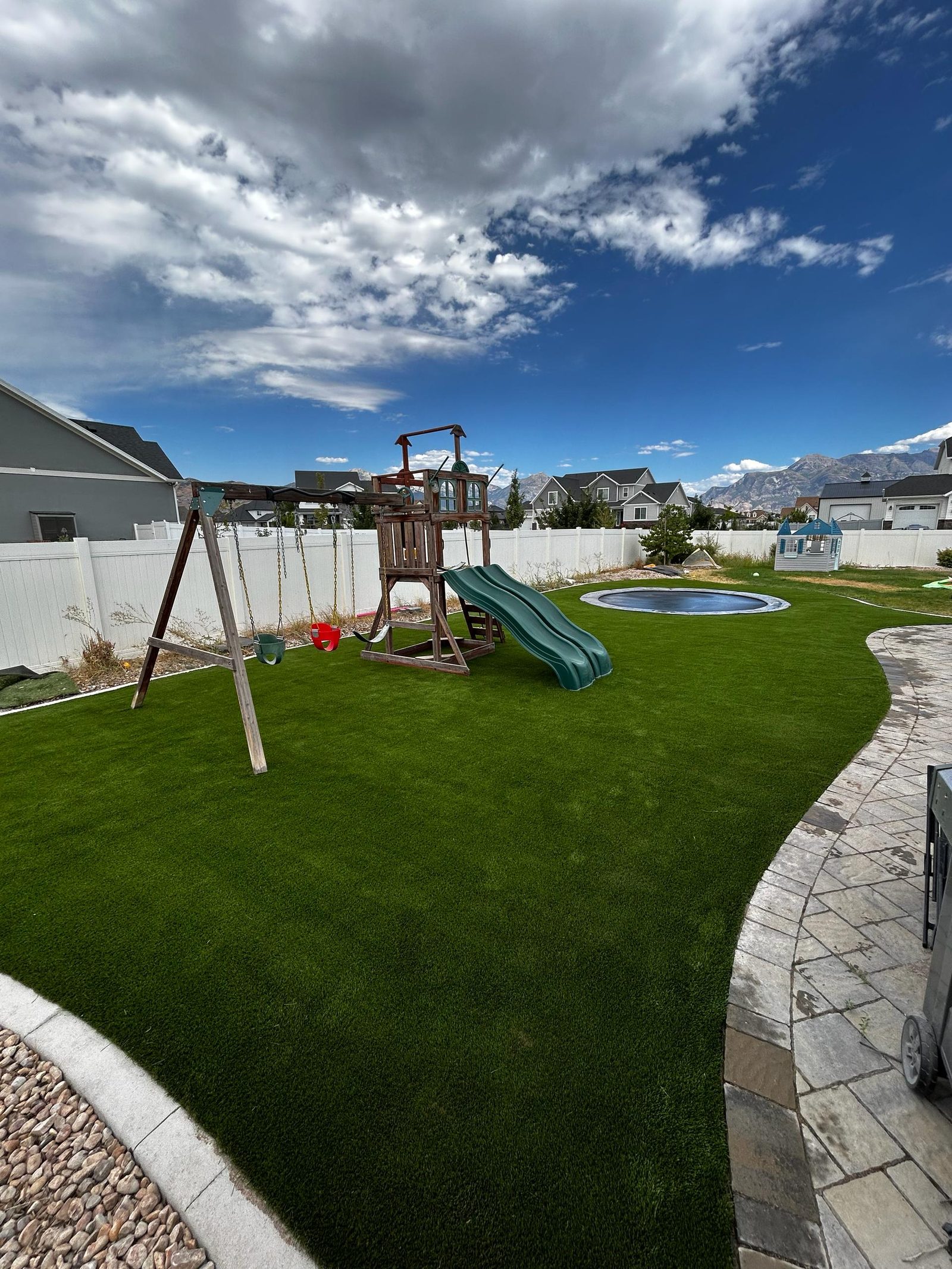 Artificial turf installation in Utah. Play area with slide & swings
