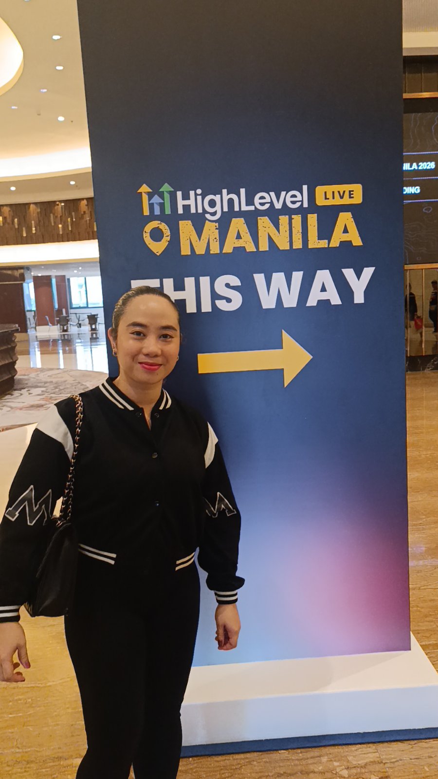 Krisilda at HighLevel Live Manila — this way sign