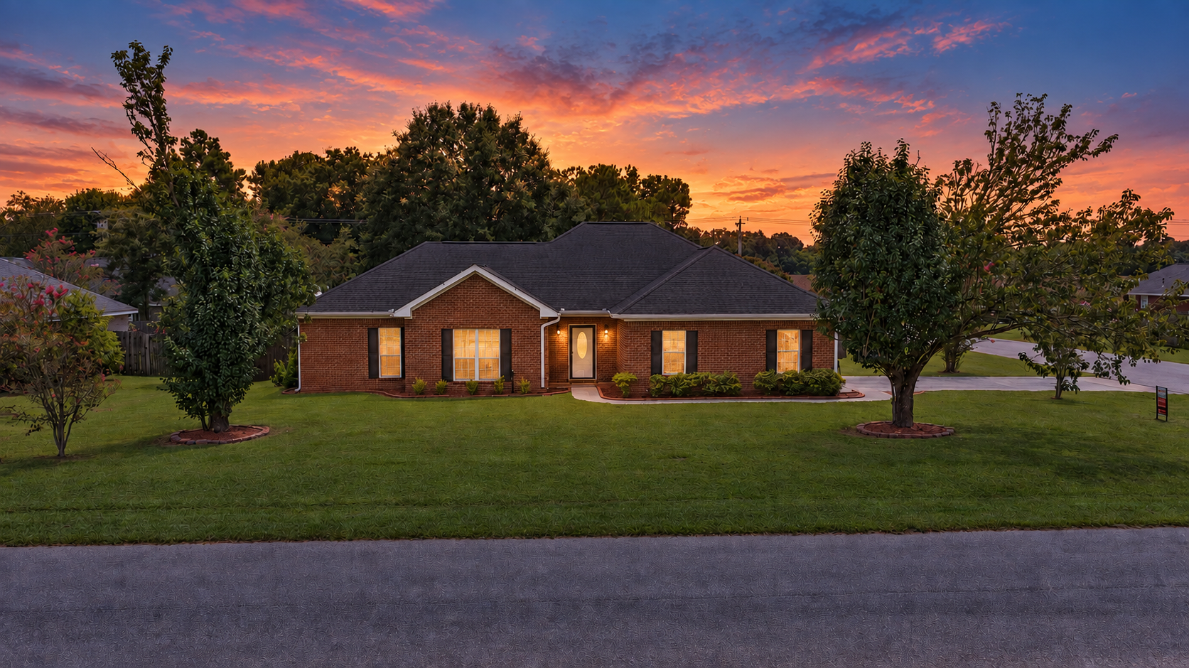 The same Robertsdale home photographed at twilight with warm interior lights on and a colored sky behind the roofline
