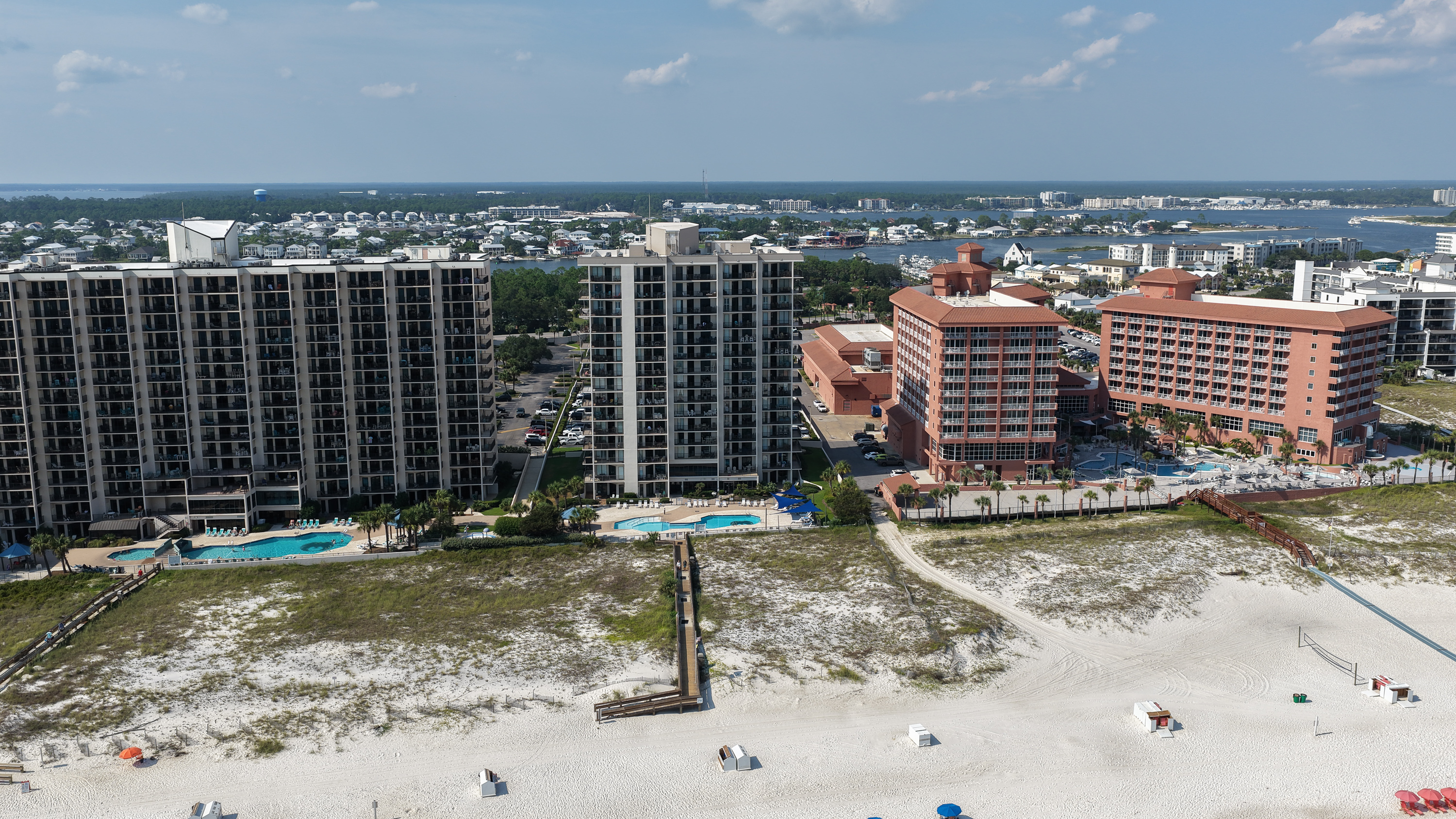 Aerial view of the Phoenix East II pool deck and Gulf shoreline in Orange Beach, Alabama
