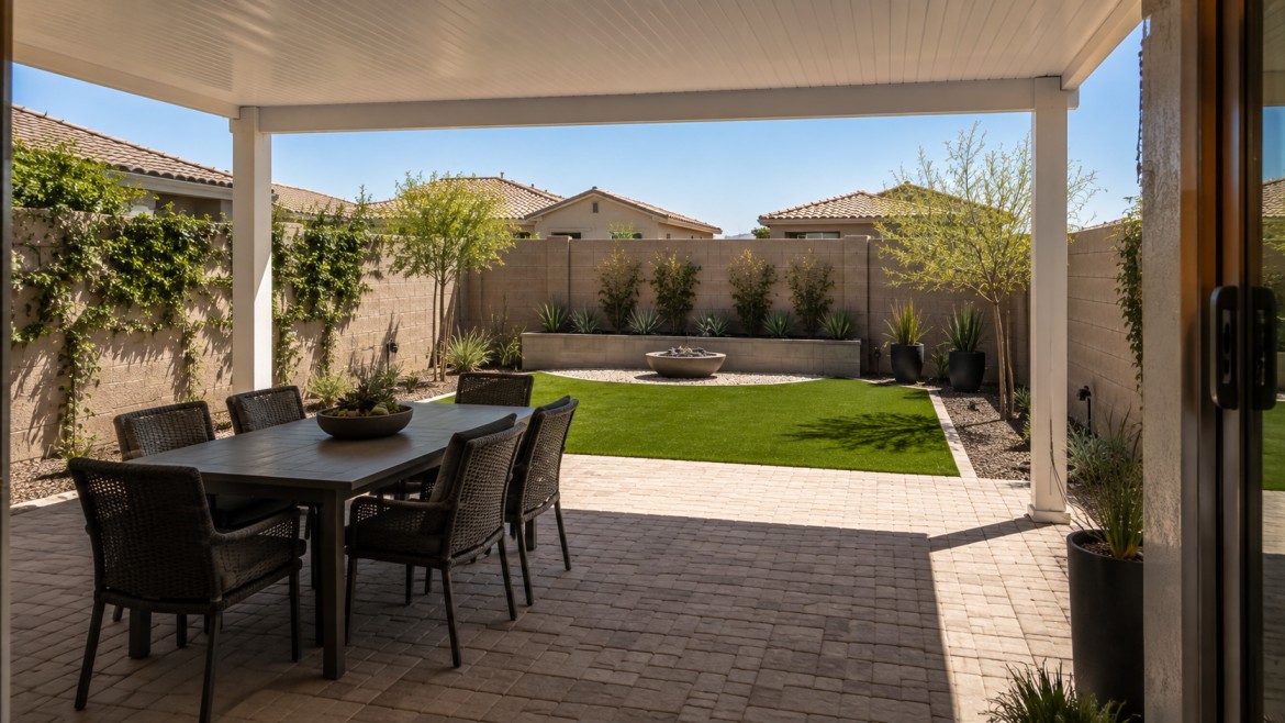 Small backyard divided into a covered dining zone and an open artificial turf zone